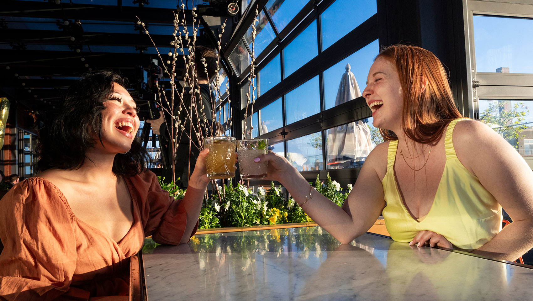 women laughing with cocktails at The Outsider