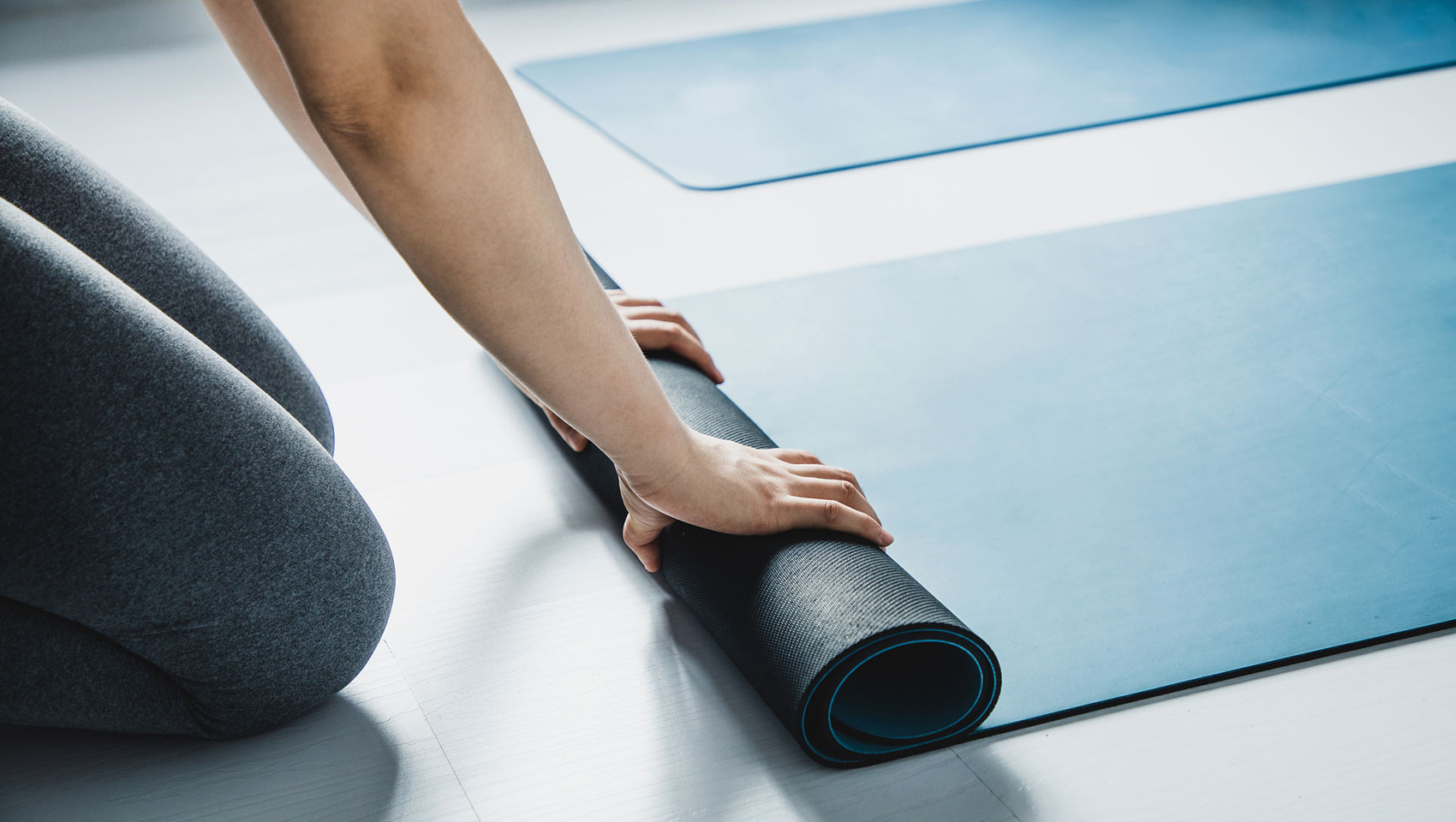 Woman rolling up yoga mat